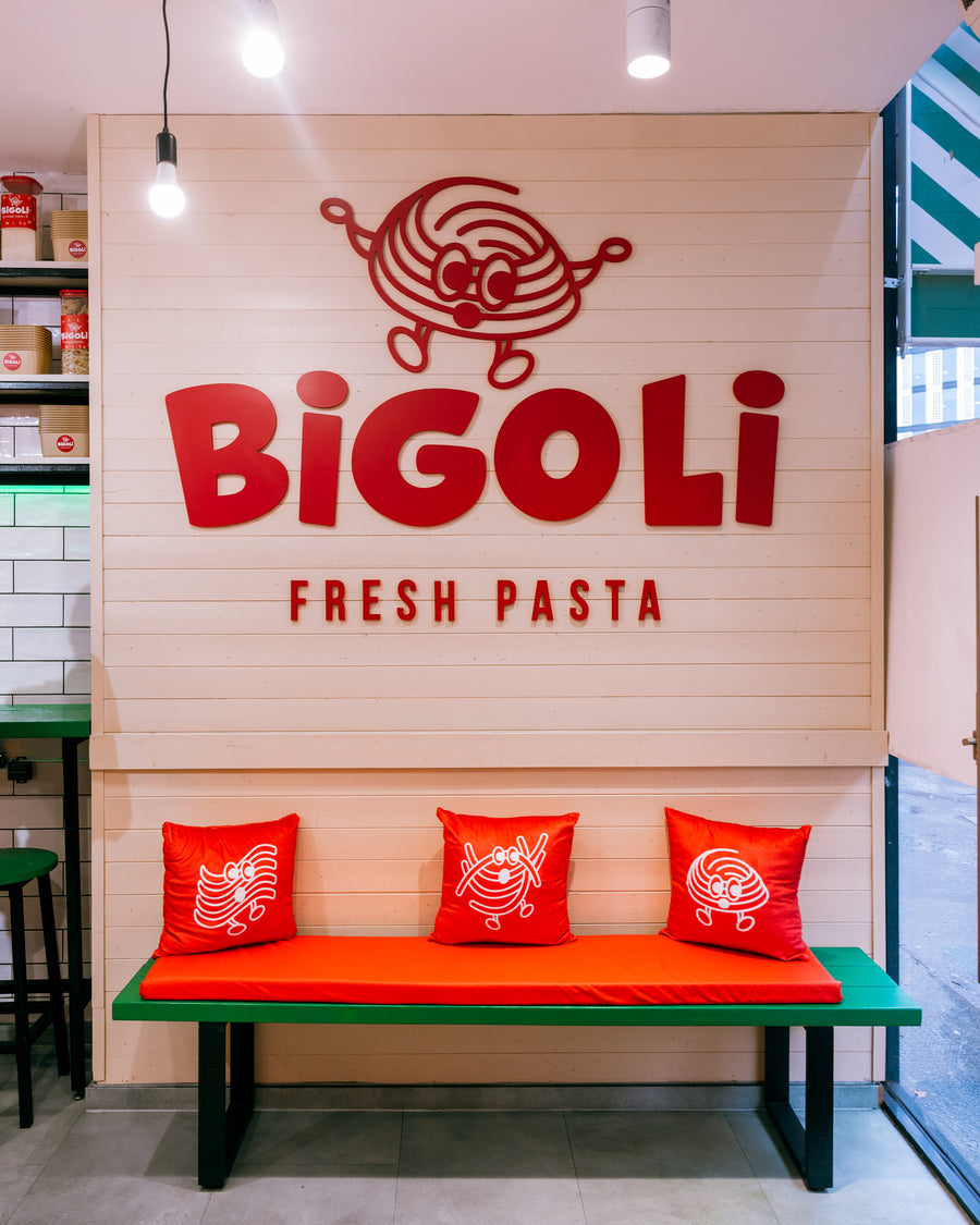 The BIGOLI FRESH PASTA sign above the red bench seating inside the Old Street shop