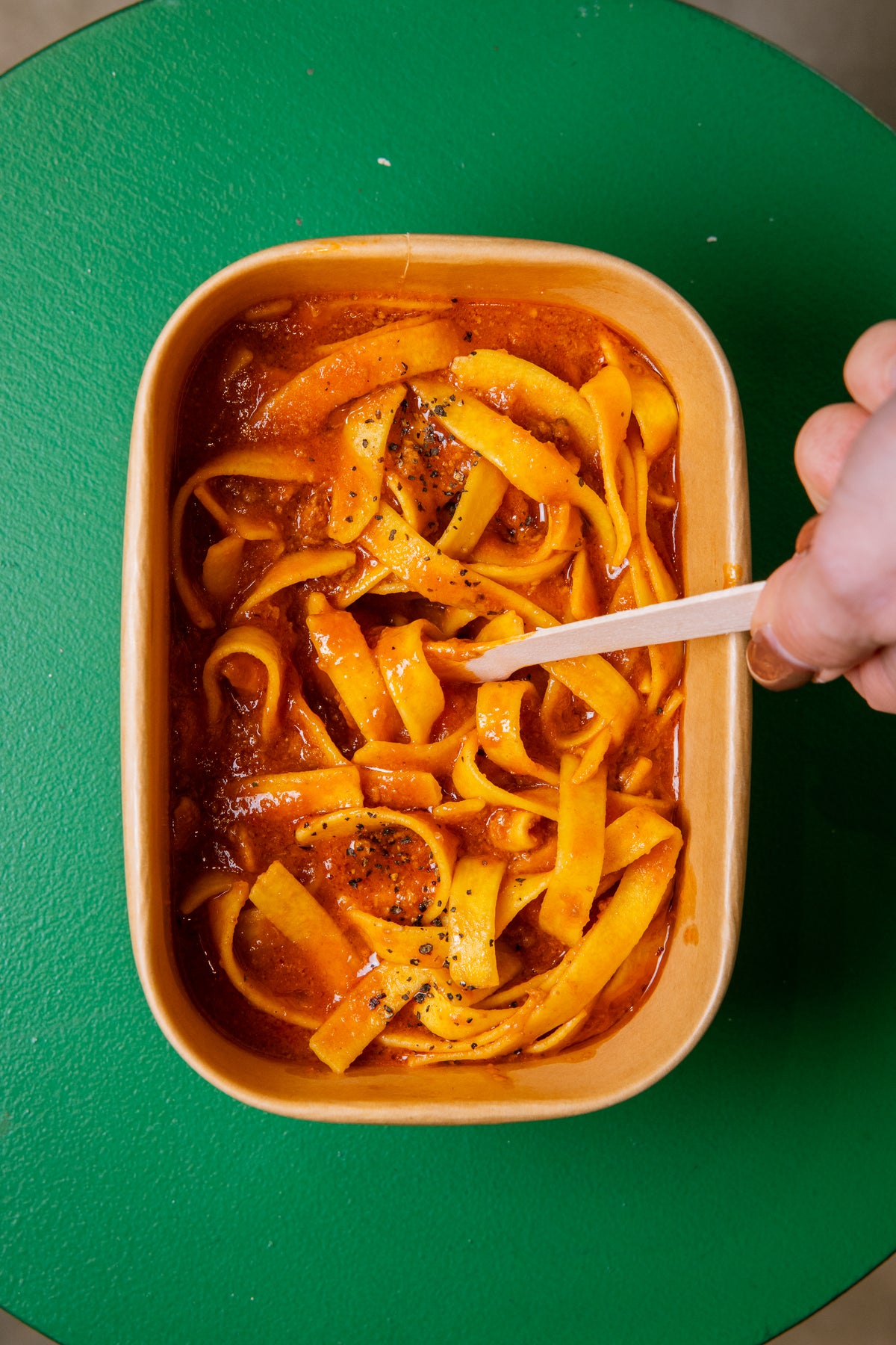 A forkful of fresh fettuccine lifted from a Bigoli takeaway box